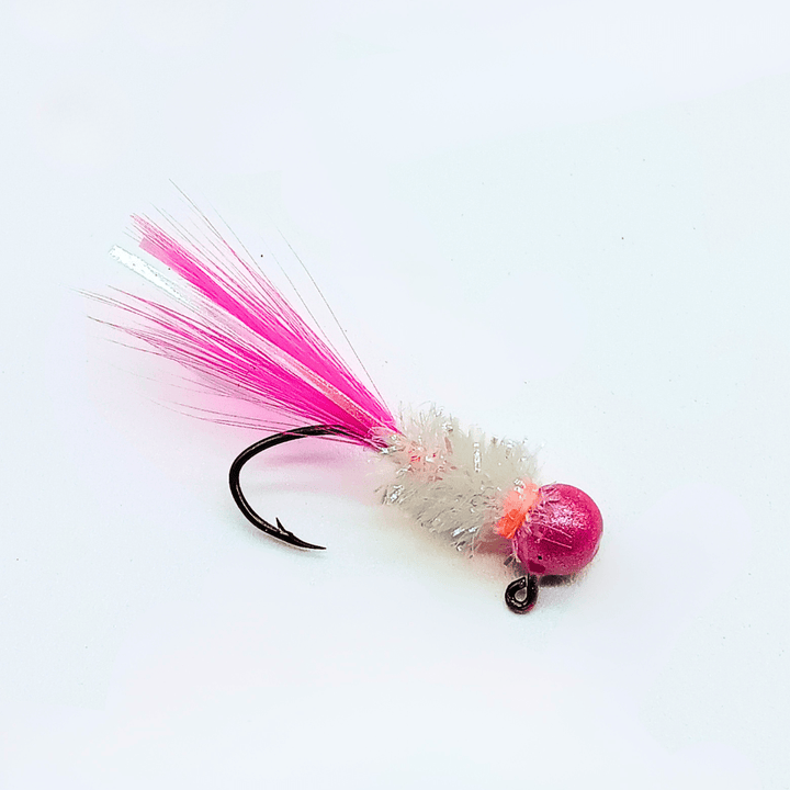 Hand tied crappie jig with a pink feather tail, a white sparkly body made of synthetic material, and a round pink jig head. This crappie lure features a sickle hook, designed to attract fish by mimicking the appearance and movement of prey in the water, making it an effective and visually appealing bait for crappie fishing. This fishing lure is hand tied by Ramble Tamble Tackle.